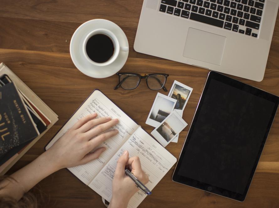 A journal and coffee on a table, representing reflection and questions about therapy.